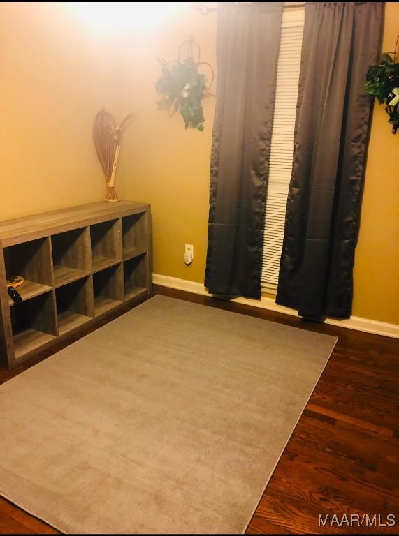 interior space featuring baseboards and wood finished floors