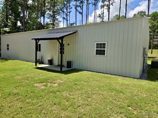 rear view of property with metal roof and a lawn