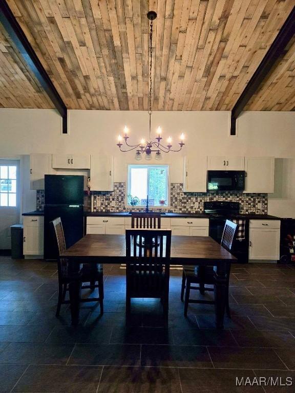 dining area featuring plenty of natural light, lofted ceiling with beams, wooden ceiling, and a chandelier