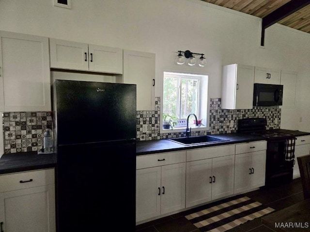 kitchen with black appliances, dark countertops, a sink, and white cabinetry