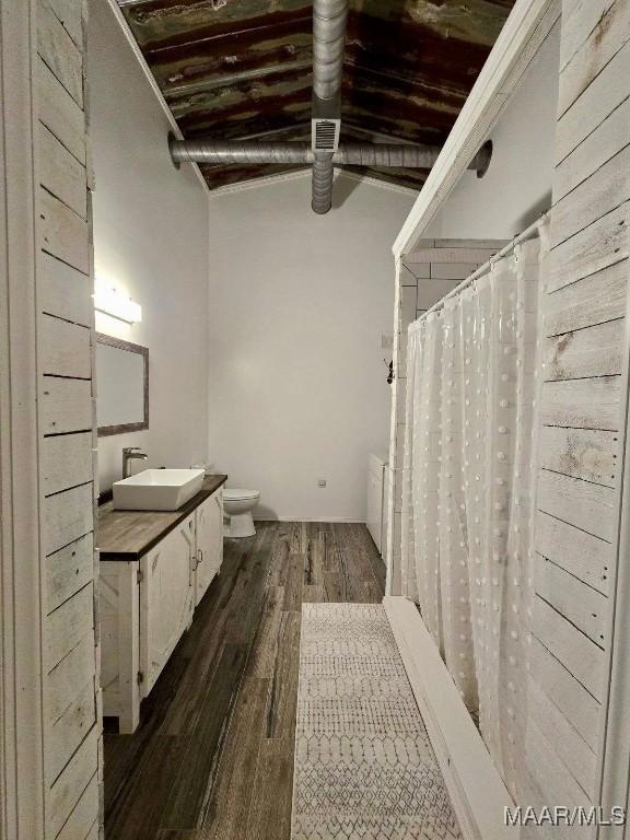 full bath with toilet, a shower with curtain, wood finished floors, and vanity