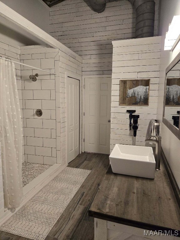 bathroom featuring a sink, a shower stall, and wood finished floors