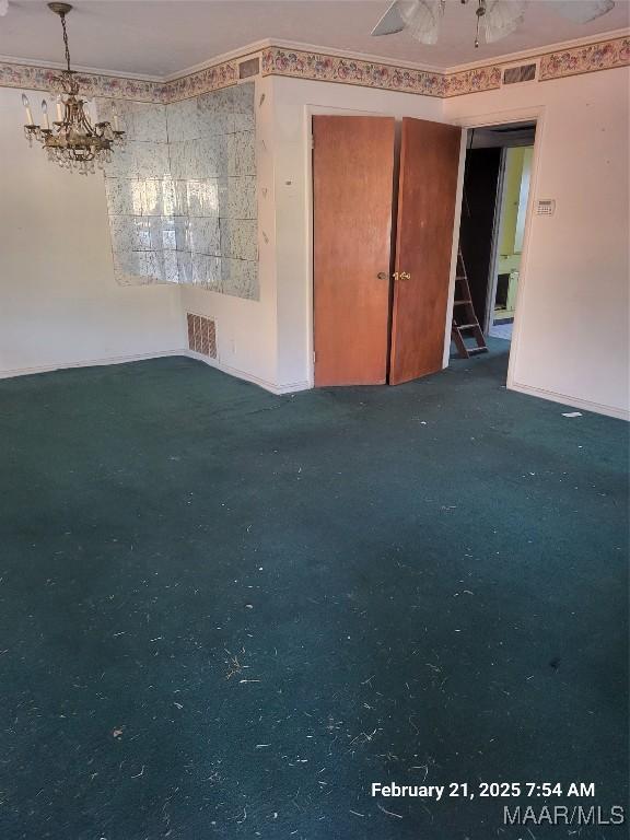 spare room with ornamental molding, visible vents, and an inviting chandelier