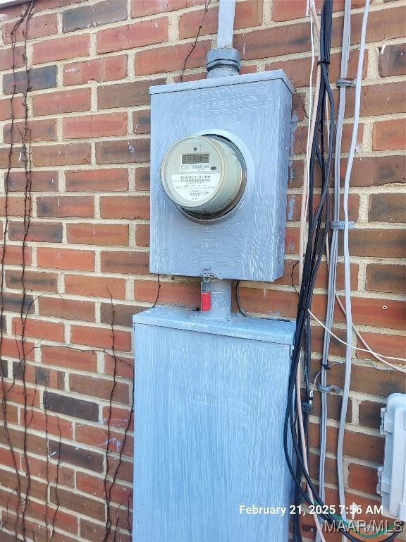 details featuring brick siding and electric meter