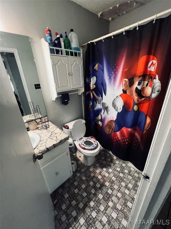 full bath featuring toilet, curtained shower, a textured ceiling, and vanity