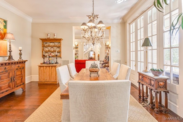 dining area featuring a chandelier, visible vents, crown molding, and wood finished floors