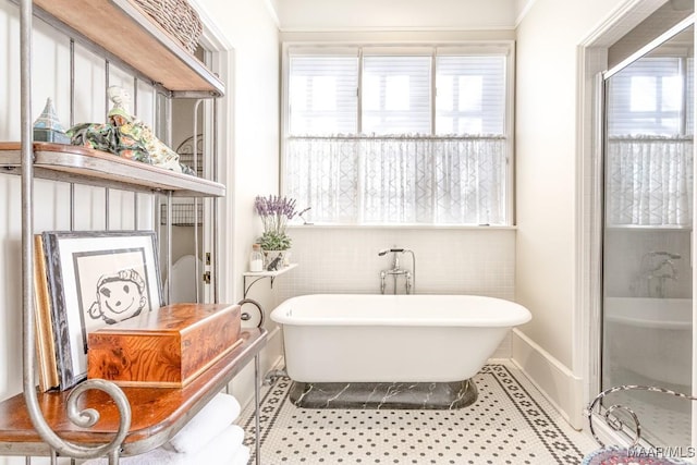 full bath with a freestanding tub and tile patterned floors