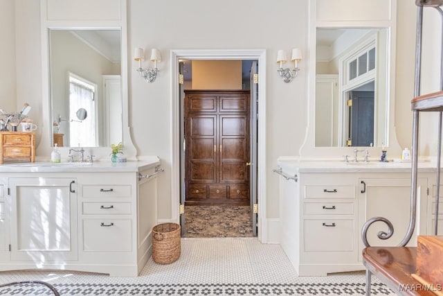 bathroom featuring a sink, ornamental molding, and two vanities