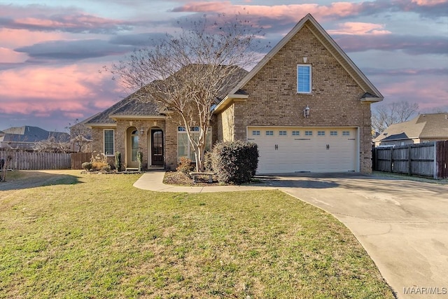 traditional-style home with fence, a lawn, and brick siding