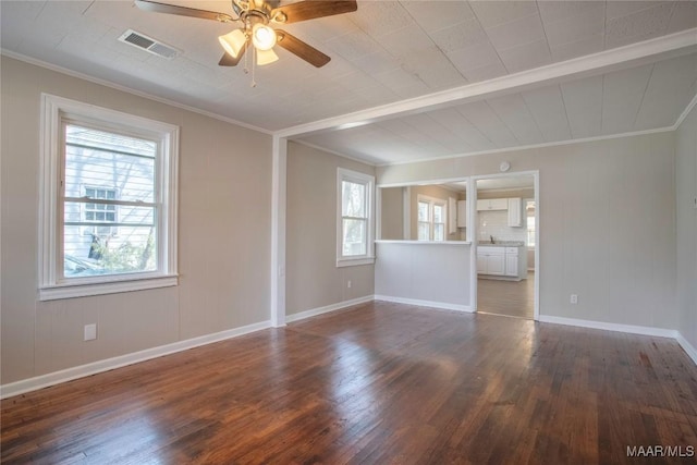 unfurnished room with a ceiling fan, baseboards, visible vents, dark wood finished floors, and crown molding