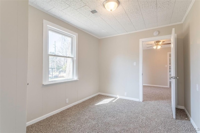 carpeted empty room featuring baseboards and ornamental molding