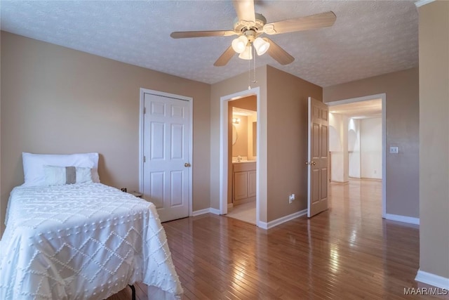 bedroom featuring wood-type flooring, baseboards, ceiling fan, and a textured ceiling