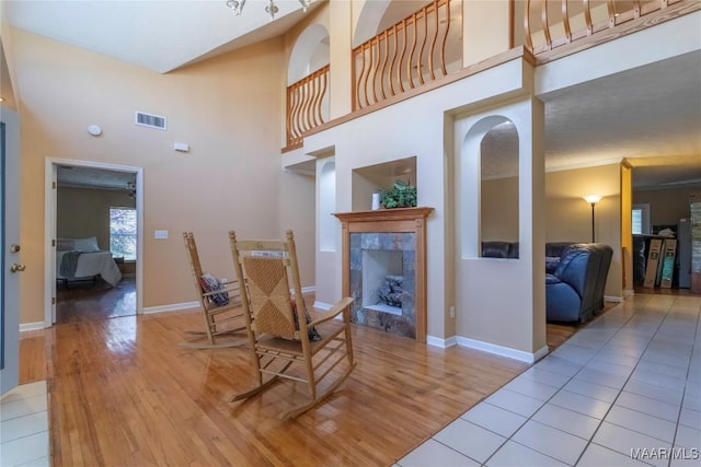 dining area with a premium fireplace, wood finished floors, visible vents, and baseboards