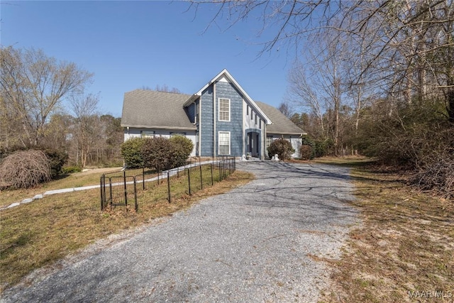 view of front facade with driveway and fence