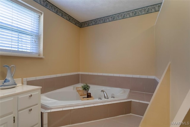 bathroom featuring a textured ceiling, a bath, and vanity