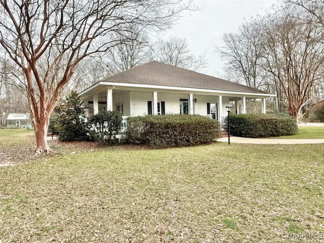 view of front facade featuring a porch, a shingled roof, and a front lawn