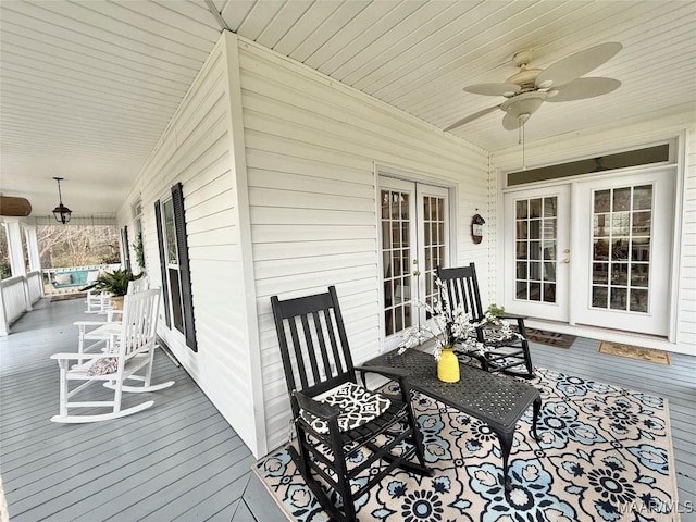 wooden deck featuring ceiling fan, a porch, and french doors