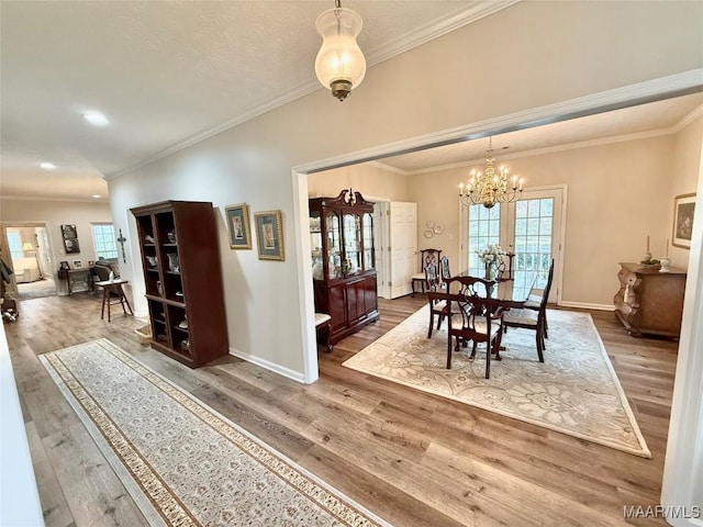 dining room featuring crown molding, wood finished floors, a wealth of natural light, and baseboards