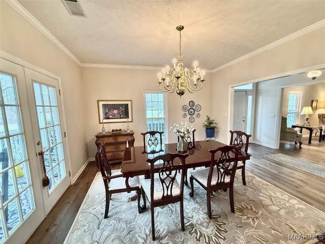 dining room with visible vents, ornamental molding, dark wood-type flooring, a textured ceiling, and french doors