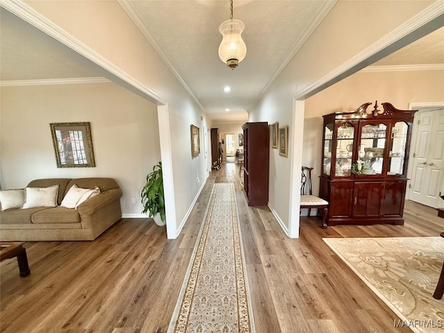 hall with crown molding, recessed lighting, wood finished floors, and baseboards