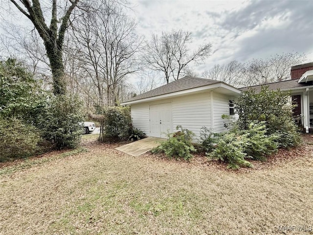 view of property exterior with an outbuilding and a lawn