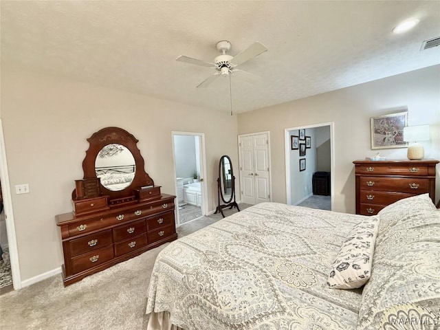 carpeted bedroom with baseboards, visible vents, ceiling fan, and ensuite bathroom