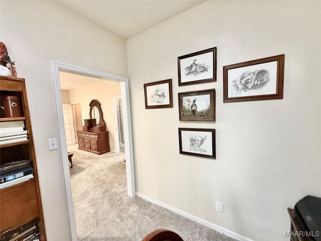 hall featuring carpet and baseboards