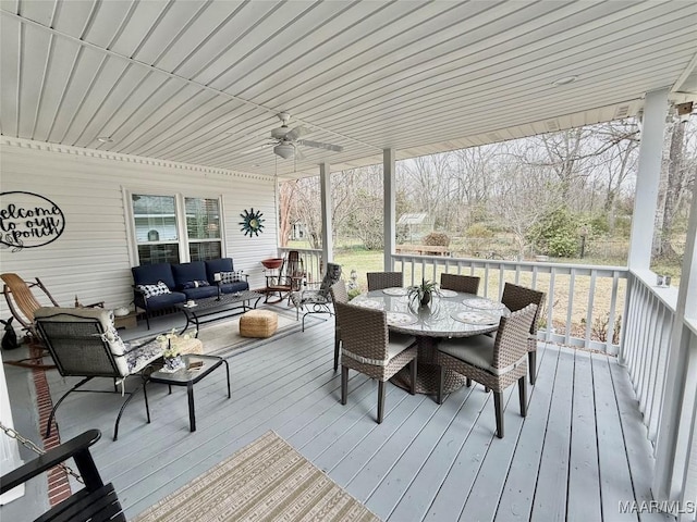 wooden terrace with a ceiling fan, outdoor dining space, and an outdoor hangout area