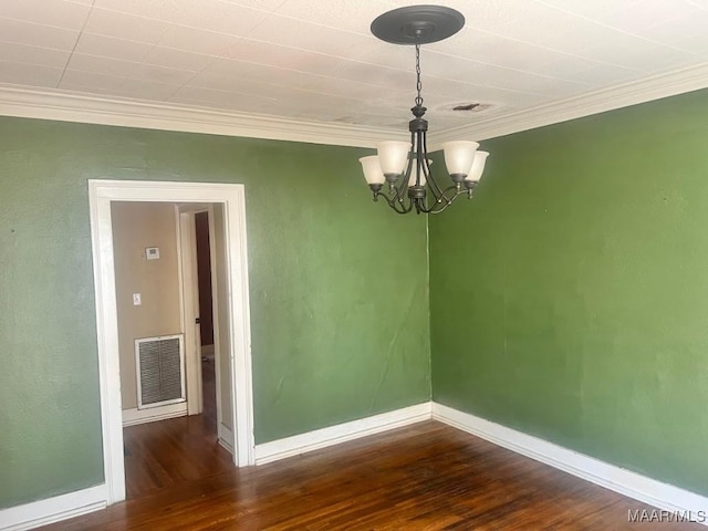 empty room featuring visible vents, a chandelier, dark wood-type flooring, and ornamental molding