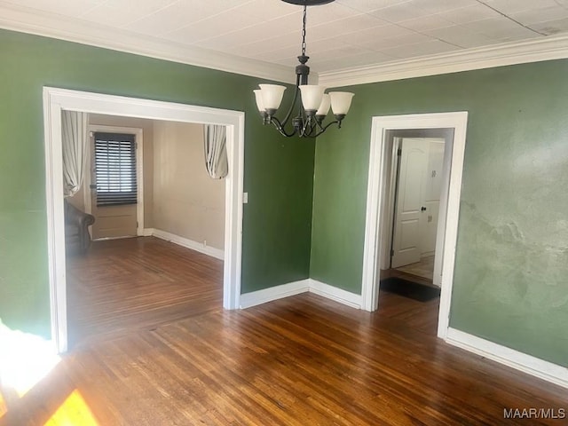 spare room featuring a chandelier, baseboards, parquet flooring, and crown molding