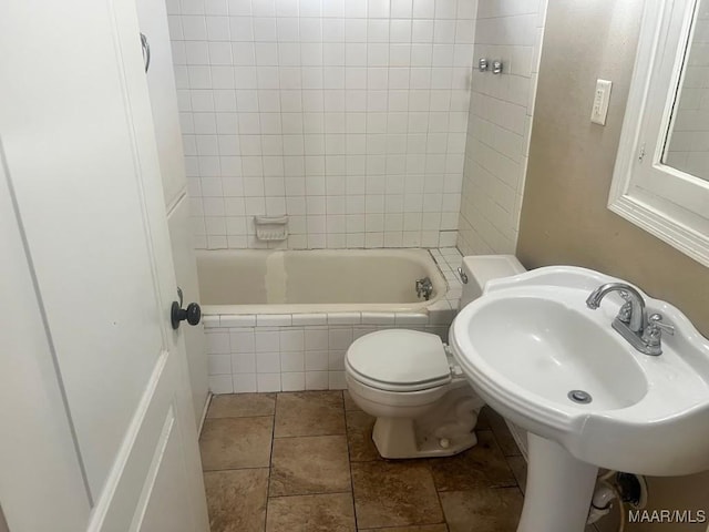 bathroom featuring tiled shower / bath combo, a sink, and toilet