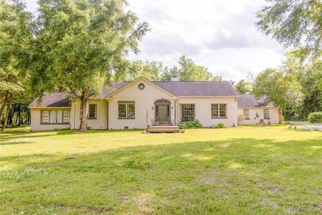 rear view of property featuring a yard, crawl space, and a chimney