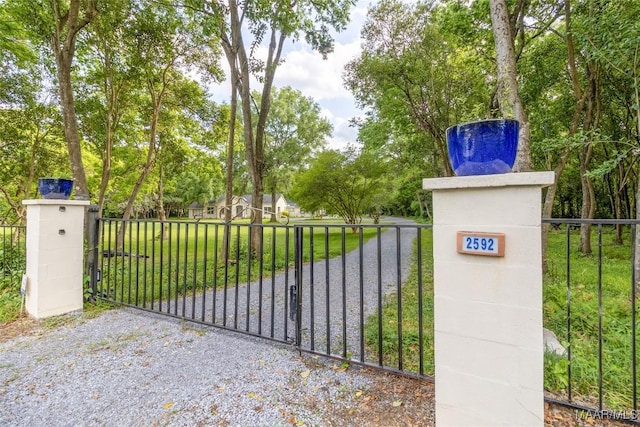 view of gate with a lawn and fence