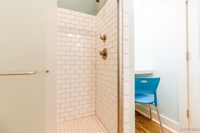 full bathroom featuring a shower stall, baseboards, and wood finished floors