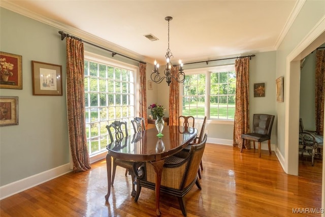 dining area featuring plenty of natural light, wood finished floors, visible vents, and crown molding