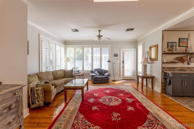 living room featuring visible vents, wood finished floors, and ornamental molding