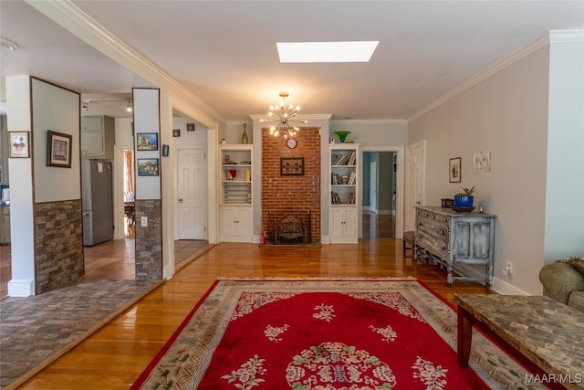 living room with a chandelier, a skylight, crown molding, and wood finished floors