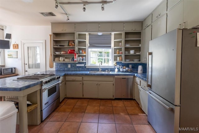 kitchen with stainless steel appliances, a sink, decorative backsplash, and open shelves