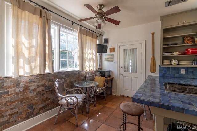 dining room with a ceiling fan, tile patterned flooring, visible vents, and baseboards