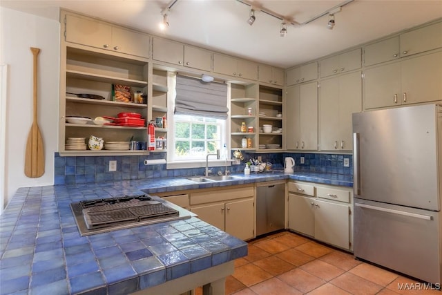 kitchen featuring light tile patterned floors, tasteful backsplash, stainless steel appliances, open shelves, and a sink