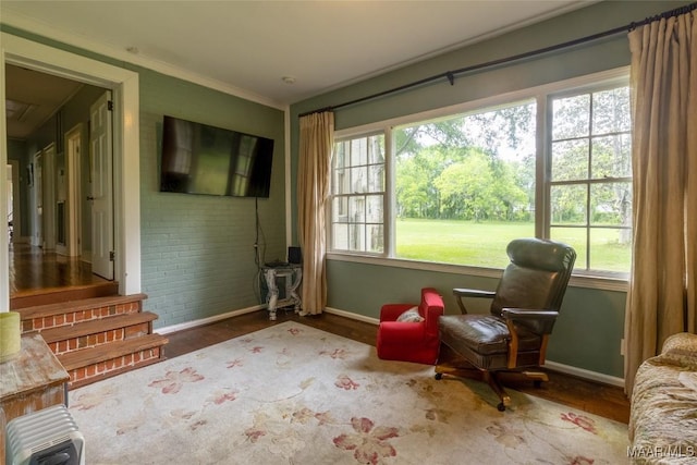 living area with a wealth of natural light, baseboards, and wood finished floors