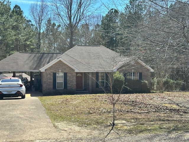 single story home featuring a carport, brick siding, a shingled roof, and driveway