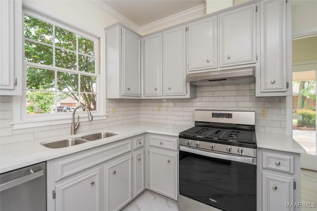 kitchen featuring stainless steel appliances, tasteful backsplash, light countertops, a sink, and under cabinet range hood