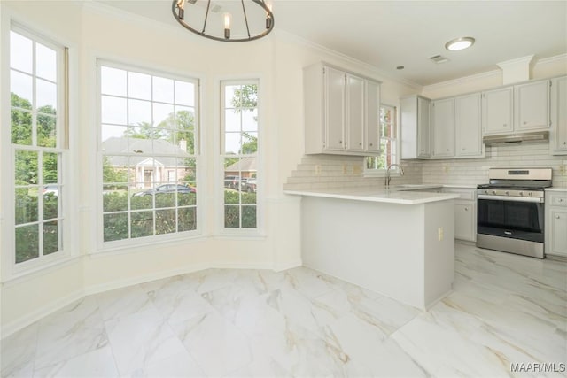 kitchen with marble finish floor, stainless steel range oven, crown molding, and under cabinet range hood