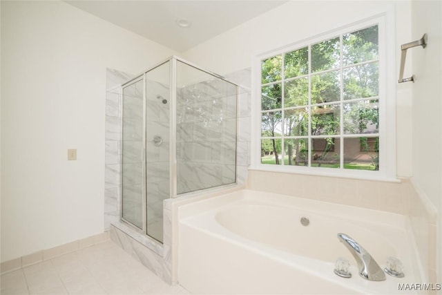 bathroom featuring a garden tub, a shower stall, and tile patterned floors