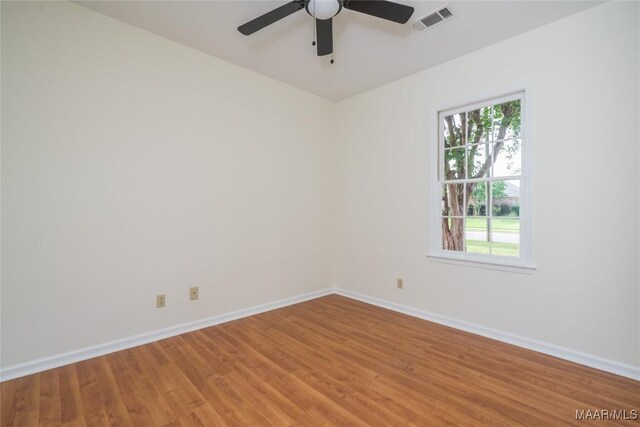 unfurnished room with baseboards, visible vents, light wood-style flooring, and a ceiling fan