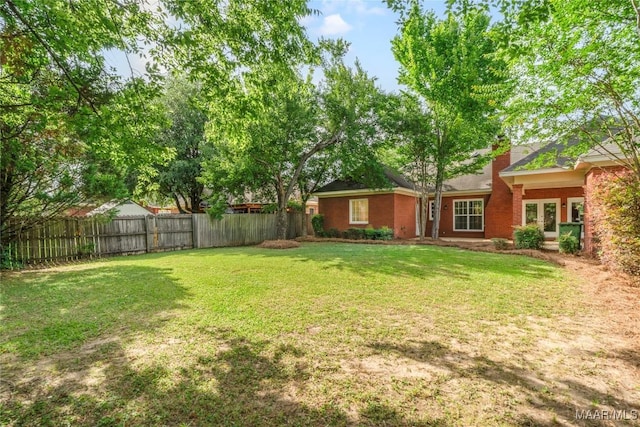 view of yard with french doors and fence