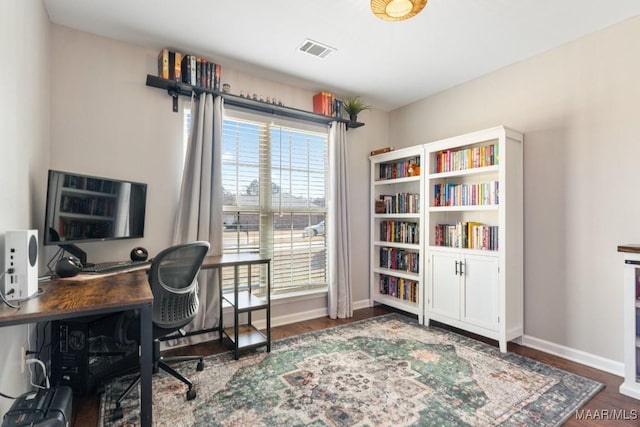 office space featuring wood finished floors, visible vents, and baseboards