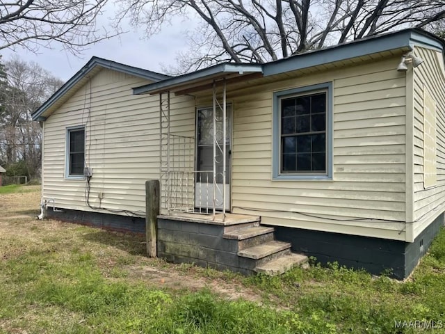 view of home's exterior with crawl space and a lawn