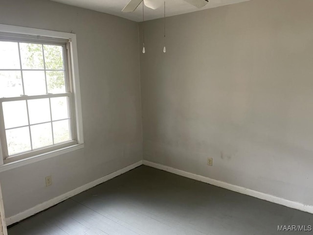 spare room featuring ceiling fan, baseboards, and wood finished floors